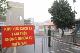 Lực lượng chức năng lập chốt tại cổng trường tiểu học Xuân Phương. (Ảnh: Minh Quyết/TTXVN)