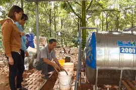 Ông Đỗ Lương Ý hướng dẫn người dân xã Nhân Nghĩa, huyện Cẩm Mỹ, tỉnh Đồng Nai sử dụng hệ thống tưới 3 trong 1. (Ảnh: Lê Xuân/TTXVN)
