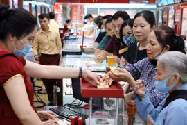 Khách hàng giao dịch vàng miếng. (Ảnh: Đức Duy/Vietnam+)