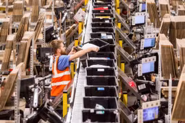 Một công nhân sắp xếp các hộp chứa đơn hàng tại một trung tâm của Amazon tại Italy. (Nguồn: ft.com)