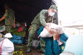 Bộ đội Biên phòng Tiền Giang tham gia vận chuyển gạo, rau củ quả cùng các hàng nhu yếu phẩm cho một khu vực phong tỏa. (Ảnh: Hữu Chí/TTXVN)