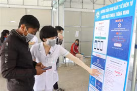 Nhân viên Bệnh viện Đa khoa tỉnh Kon Tum hỗ trợ người dân khai báo y tế và quét mã QR trên ứng dụng VietNam Health Declaration. (Ảnh: Dư Toán/TTXVN)