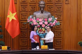 Thủ tướng Phạm Minh Chính trao Quyết định bổ nhiệm Tổng Giám đốc Thông tấn xã Việt Nam cho bà Vũ Việt Trang. (Ảnh: Dương Giang/TTXVN)