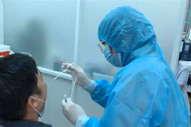 Nhân viên Trung tâm Y tế Quận 3 lấy mẫu xét nghiệm cho người dân. (Ảnh: Đinh Hằng/TTXVN)