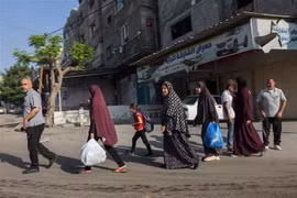 Người dân Palestine sơ tán tới các khu vực an toàn sau các cuộc không kích của Israel, ngày 13/10. (Ảnh: AFP/TTXVN)