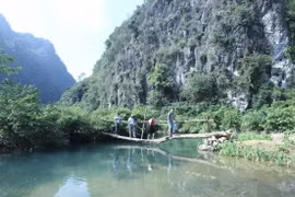 Du khách trải nghiệm vượt cầu Bảy Đời bắc qua suối Mỏ Mạ làm từ một thân cây tại Khu dã ngoại tại thôn Làng Áng của xã Yên Thịnh, huyện Hữu Lũng, tỉnh Lạng Sơn. (Ảnh: Anh Tuấn/TTXVN)