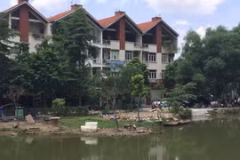 Một phần hồ bị người dân đổ đất đá, vật liệu san lấp lấn chiếm. (Ảnh: Nguyễn Văn Cảnh/TTXVN)