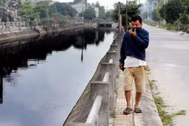 Người dân đi qua khu vực sông Đoan Túc cũng không thể chịu được mùi hôi thối của dòng sông. (Ảnh: Thế Duyệt/TTXVN)