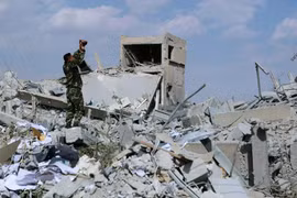 Một binh sỹ Syria quay phim lại cảnh đổ nát sau cuộc không kích của liên quân. (Nguồn: abc.net.au)
