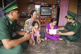 Cán bộ đồn Biên phòng Phú Mỹ trao tiền cho học sinh nghèo ở ấp Cả Ngay, xã Phú Mỹ, huyện Giang Thành, Kiên Giang. (Ảnh: Nguyễn Vũ Thành Đạt/TTXVN)