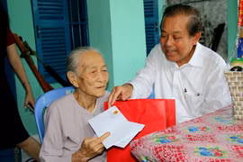 Phó Thủ tướng Thường trực Chính phủ Trương Hòa Bình tặng quà Tết cho bà Lê Thị Sử, cư trú tại phường Thanh Hải, thành phố Phan Thiết, tỉnh Bình Thuận. (Ảnh: Nguyễn Thanh/TTXVN)