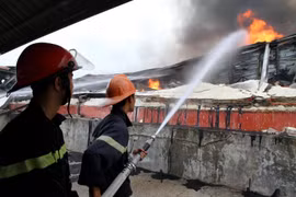 Lực lượng phòng cháy chữa cháy tích cực dập lửa tại khu vực cháy. (Ảnh: Trung Kiên/TTXVN)
