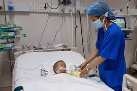 Bệnh Nhi Đặng Bảo A. sau khi phẫu thuật được hồi sức tại Bệnh viện đa khoa Đồng Nai. (Ảnh: Lê Xuân/TTXVN)