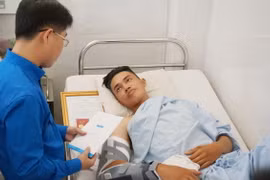 Đồng chí Phạm Hồng Sơn, Ủy viên Ban thường vụ Trung ương Đoàn, Bí thư Thành đoàn Thành phố Hồ Chí Minh trao huy hiệu “Tuổi trẻ dũng cảm” cho “hiệp sỹ” Đinh Phú Quý. (Ảnh: Đinh Hằng/TTXVN)