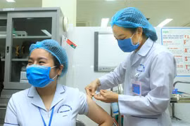 Điều dưỡng viên khu cách ly Bệnh viện Việt Tiệp cơ sở 2 Bùi Thị Thanh Nhung, sinh năm 1987, được tiêm mũi liều vaccine ngừa COVID-19 đầu tiên tại Hải Phòng. (Ảnh: An Đăng/TTXVN)