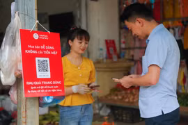 Người dân có thể dễ dàng thanh toán một bó rau hoặc một túi hoa quả chỉ bằng việc quét mã QR hoặc chuyển tiền qua số điện thoại. (Ảnh: Minh Sơn/Vietnam+)
