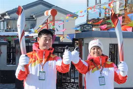 Hai vận động viên Ding Hui (trái) và Dong Qingping tham gia lễ rước đuốc Olympic mùa Đông Bắc Kinh 2022 tại Hà Bắc (Trung Quốc), ngày 3/2/2022. (Ảnh: THX/TTXVN)
