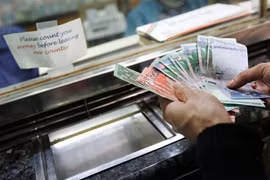 Kiểm tiền ringgit của Malaysia tại một quầy giao dịch tiền tệ ở Kuala Lumpur. (Ảnh: AFP/TTXVN)