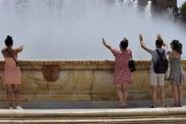 Người dân tránh nóng bên vòi phun nước tại Seville (Tây Ban Nha), ngày 10/7/2021. (Ảnh: AFP/TTXVN)