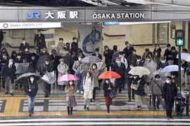 Người dân đeo khẩu trang phòng dịch COVID-19 khi đi trên đường phố ở Osaka (Nhật Bản), ngày 22/3/2022. (Ảnh: Kyodo/TTXVN)