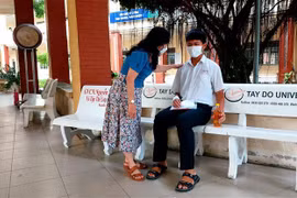 Giám thị điểm thi trường THPT Bùi Hữu Nghĩa dặn dò thí sinh Tạ Quốc Hùng trước khi vào phòng thi. Ảnh: Thu Hiền - TTXVN