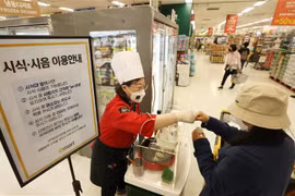 Nhân viên giới thiệu đồ ăn cho khách tại một siêu thị ở Seoul (Hàn Quốc) ngày 25/4/2022, khi hoạt động ăn uống được phép nối lại tại đây. (Ảnh: Yonhap/TTXVN)