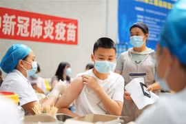 Nhân viên y tế tiêm vaccine ngừa COVID-19 cho học sinh tại Quý Châu (Trung Quốc). (Ảnh: THX/TTXVN)