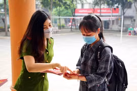 Cán bộ, chiến sỹ Cục Cảnh sát Quản lý hành chính và trật tự xã hội (Bộ Công an) hướng dẫn người dân đến đăng ký tài khoản định danh điện tử. (Ảnh: Phạm Kiên/TTXVN)
