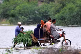 Người dân sơ tán khỏi vùng ngập lụt tại tỉnh Sindh (Pakistan), ngày 25/8/2022. (Ảnh: THX/TTXVN)