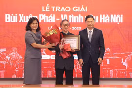 Bà Nguyễn Thị Sự, Phó Tổng Giám đốc Thông tấn xã Việt Nam (trái) trao Giải thưởng Lớn cho đạo diễn Đặng Nhật Minh. (Ảnh: Hòa Nguyễn/Vietnam+)