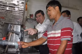 Chủ tịch UBND Thành phố Hồ Chí Minh Nguyễn Thành Phong kiểm tra việc thực hiện cung cấp nước sạch bằng thiết bị lọc nước tại hộ gia đình ông Lê Vũ Hồng ở ấp Bến Mương, xã An Nhơn Tây. (Ảnh: Thanh Vũ/TTXVN)