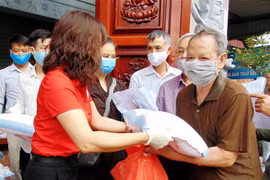 Người có hoàn cảnh khó khăn, hộ gia đình có người khuyết tật, người già... nhận quà tại chợ nhân đạo. (Ảnh: TTXVN)