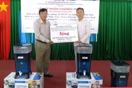 Giám đốc Sở Nông nghiệp và Phát triển nông thôn tỉnh Sóc Trăng Lương Minh Quyết tiếp nhận thiết bị lọc, xử lí nước LifeStraw từ các nhà tài trợ. (Ảnh: Trung Hiếu/TTXVN)
