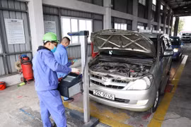 Nhân viên đăng kiểm thực hiện quy trình kiểm định xe cơ giới. (Ảnh: Minh Hiếu/Vietnam+)
