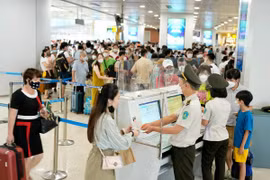 An ninh hàng không kiểm tra thủ tục đi máy bay của hành khách trước khi vào khu vực soi chiếu. (Ảnh: CTV/Vietnam+)