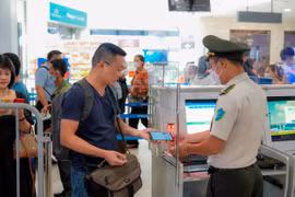 Hành khách sử dụng VNEID tại điểm kiểm soát giấy tờ tùy thân. (Ảnh: PV/Vietnam+)