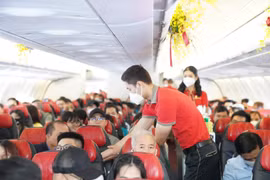 Tiếp viên của hãng hàng không Vietjet phục vụ hành khách trên một chuyến bay. (Ảnh: CTV/Vietnam+)
