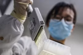 Kỹ thuật viên thử nghiệm vaccine phòng COVID-19 tại phòng thí nghiệm ở Bắc Kinh, Trung Quốc, ngày 16/3. (Ảnh: THX/TTXVN)