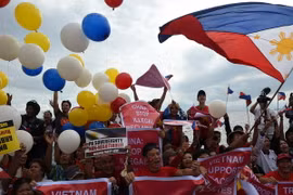 Các nhà hoạt động Philippines vui mừng sau phán quyết của Tòa Trọng tài ở Lahay trong cuộc tuần hành tại Manila ngày 12/7 vừa qua. (Ảnh: AFP/TTXVN)