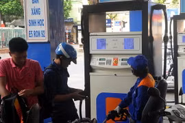 Khách hàng mua xăng tại cửa hàng kinh doanh xăng dầu của Petrolimex. (Ảnh: Quang Quyết/TTXVN)