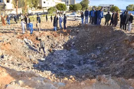 Người dân Libya vây quanh một hố bom sau cuộc không kích các mục tiêu IS tại Derna, cách thủ đô Tripoli, Libya khoảng 100km ngày 7/2 vừa qua. (Ảnh: AFP/TTXVN)