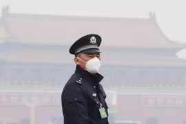 Cảnh sát Trung Quốc đeo khẩu trang tránh khói mù ô nhiễm tại thủ đô Bắc Kinh. (Ảnh: Reuters/TTXVN)
