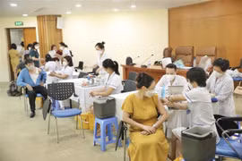 Cán bộ, công chức, viên chức và người lao động hưởng ứng tiêm vaccine mũi nhắc lại trong ngày phát động. (Ảnh: Minh Quyết/TTXVN)