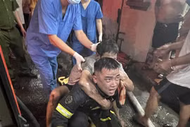 Lực lượng Cảnh sát Phòng cháy chữa cháy và cứu nạn cứu hộ đưa người bị nạn ra khỏi đám cháy. (Ảnh TTXVN phát)