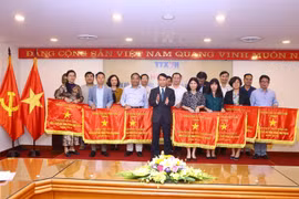 Ủy viên Trung ương Đảng, Bí thư Đảng ủy, Tổng giám đốc TTXVN Nguyễn Đức Lợi tặng Cờ thi đua của TTXVN cho 21 tập thể. (Ảnh: Minh Quyết/TTXVN)