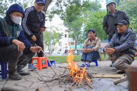 Dù ban ngày có nắng, nhưng nền nhiệt giảm sâu khiến nhiều người dân phải đốt lửa sưởi ấm. (Ảnh: Hoàng Hiếu/TTXVN)