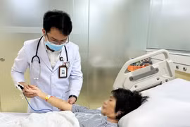 Bác sỹ Bệnh viện Đa khoa Thanh Vũ Medic Bạc Liêu kiểm tra vết ong đốt trên tay bệnh nhân T.H.C. (Ảnh: TTXVN phát)