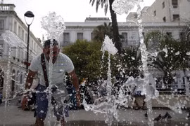 Người dân giải nhiệt tại một đài phun nước ở Algiers, Algeria ngày 10/7 vừa qua. (Ảnh: THX/TTXVN)