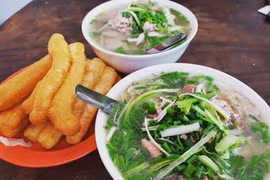 Phở Bát Đàn ăn kèm với quẩy nóng. (Ảnh: Vietnam+)