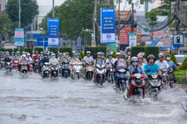 Triều cường đạt đỉnh vào ngày đầu tuần khiến việc đi lại của người dân gặp khó khăn. (Ảnh: Thanh Liêm/TTXVN)